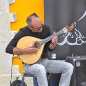 Musician playing the Portuguese guitar, in Sitio square